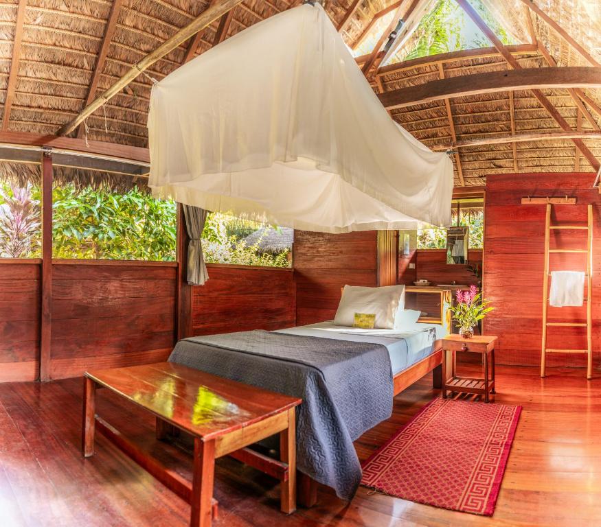 马尔多纳多港Ecolucerna Lodge Tambopata的一间卧室配有一张床和一个大型帐篷