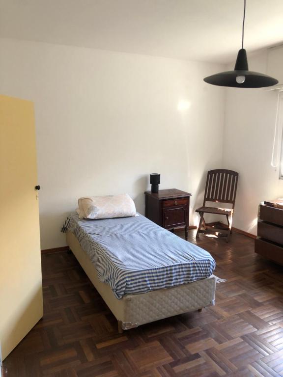 蒙得维的亚Ordeig 2223的一间卧室配有一张床、一张桌子和一把椅子