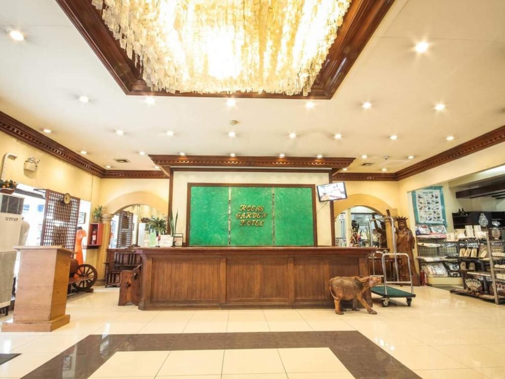 马尼拉Rosas Garden Hotel的站在商店大屏幕前的狗