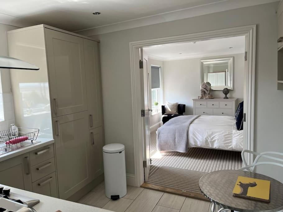 克利索普斯Beautiful Seafront Studio Apartment的一间白色卧室,配有床和一间浴室
