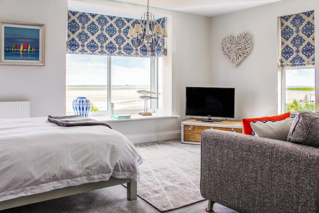 克利索普斯Seafront Apartment with Stunning Views的一间卧室配有一张床、一台电视和一张沙发