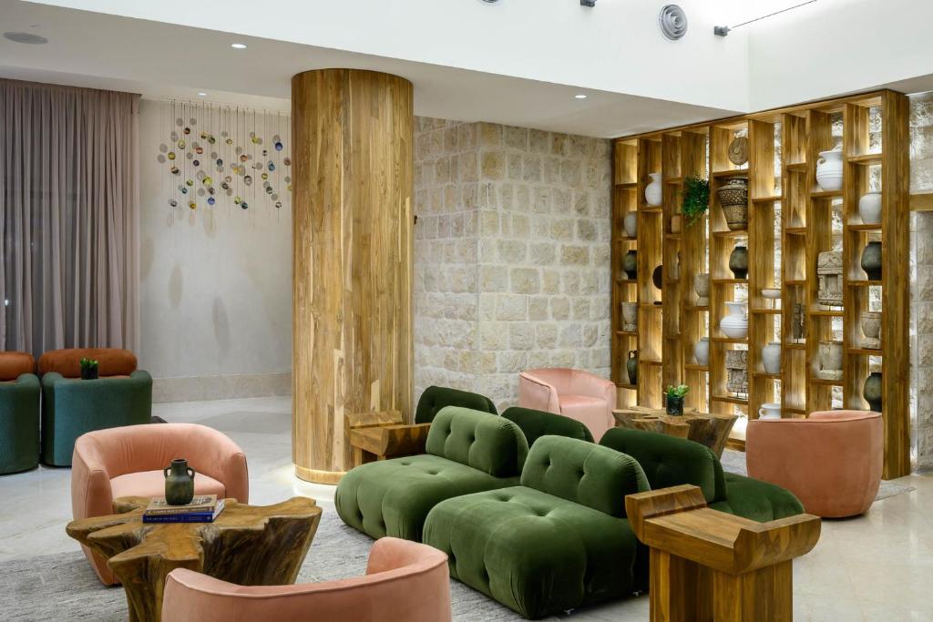 萨法德Cnaan Hotel- Limited Edition By Fattal的客厅配有绿色沙发和椅子