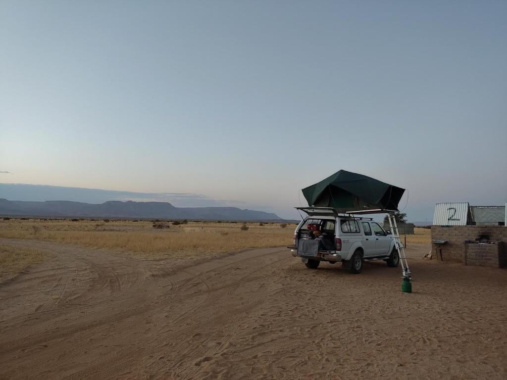 基特曼斯胡普Canyon Farmyard Camping的停在沙漠土路上的白色车辆