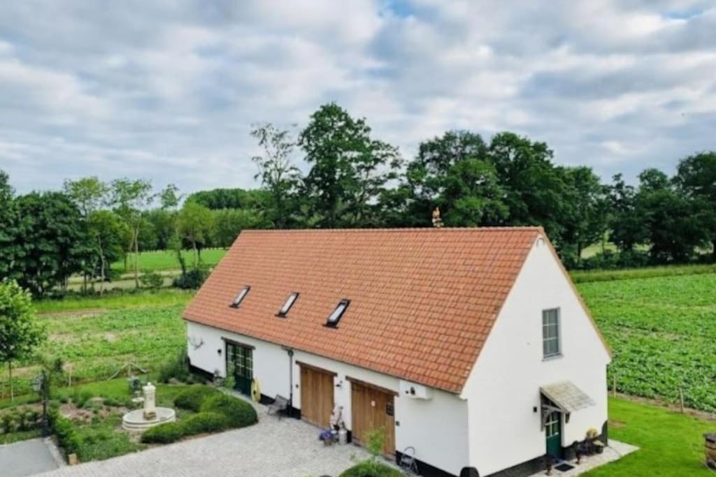 马尔德海姆Romantische vakantiewoning met weids uitzicht的一座白色的小房子,拥有橙色的屋顶