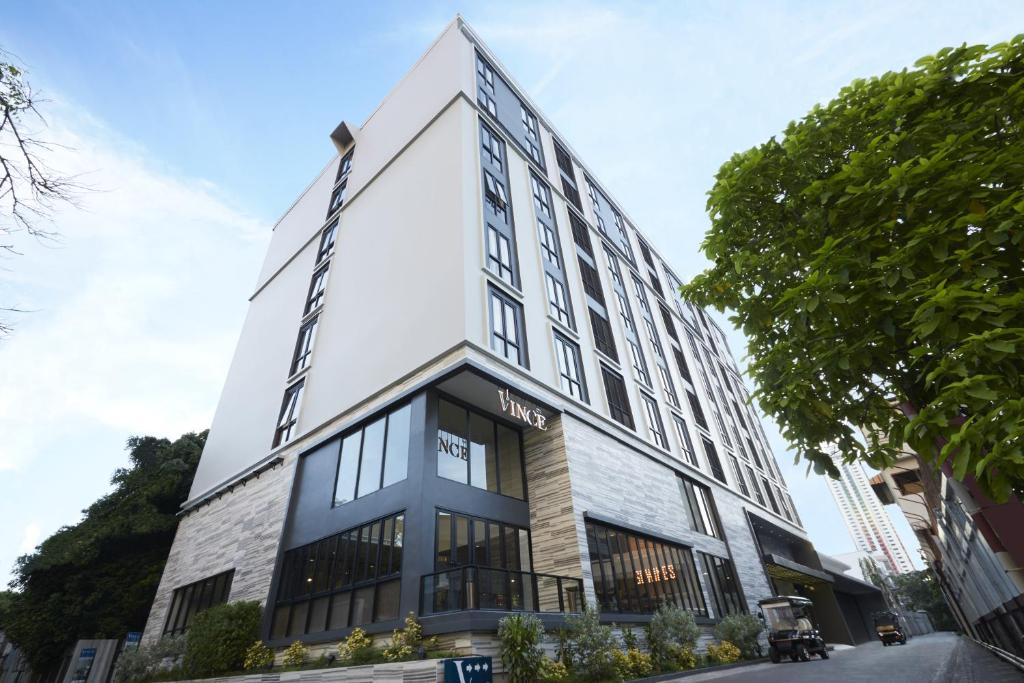 曼谷Vince Hotel Pratunam的一座高大的白色建筑,有很多窗户