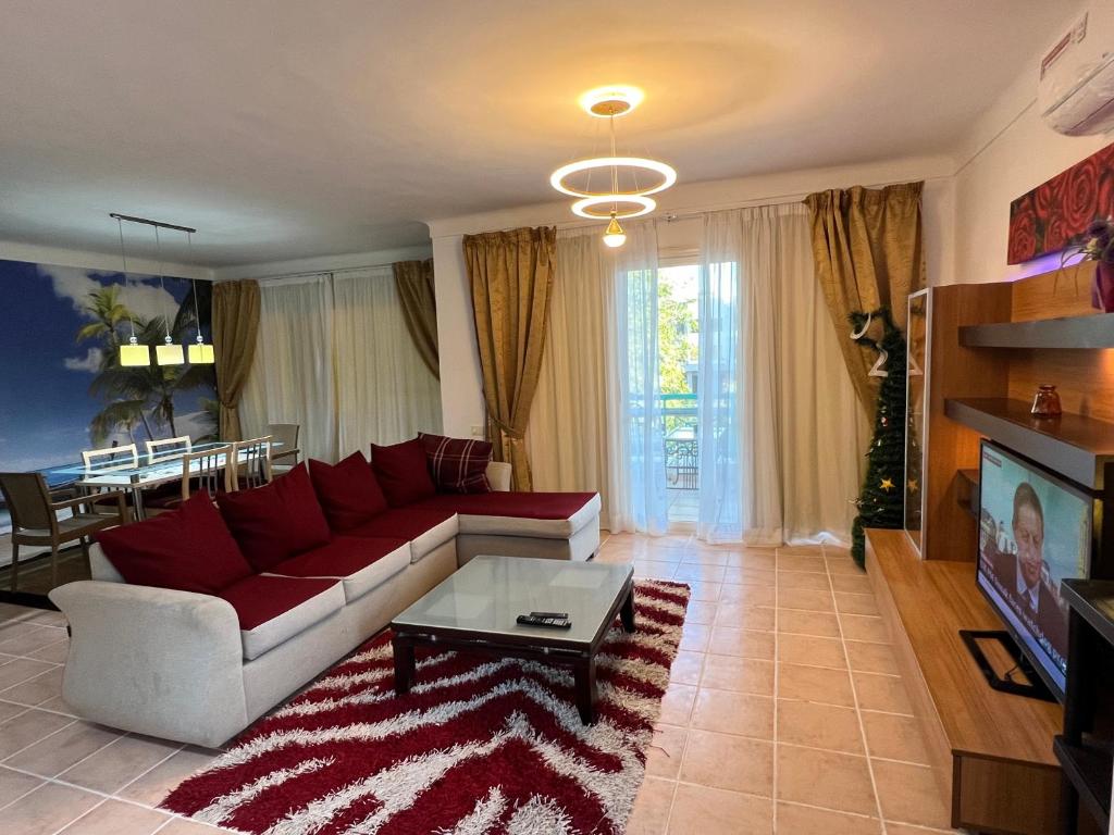 沙姆沙伊赫Luxury & stylish Naama bay flat at the centre of Sharm的客厅配有红色的沙发和桌子