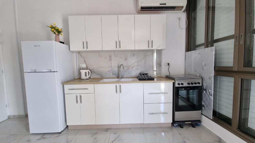 Bene BeraqNew Stylish Apartment with Balcony Close to Tel Aviv的厨房配有白色橱柜、水槽和冰箱。