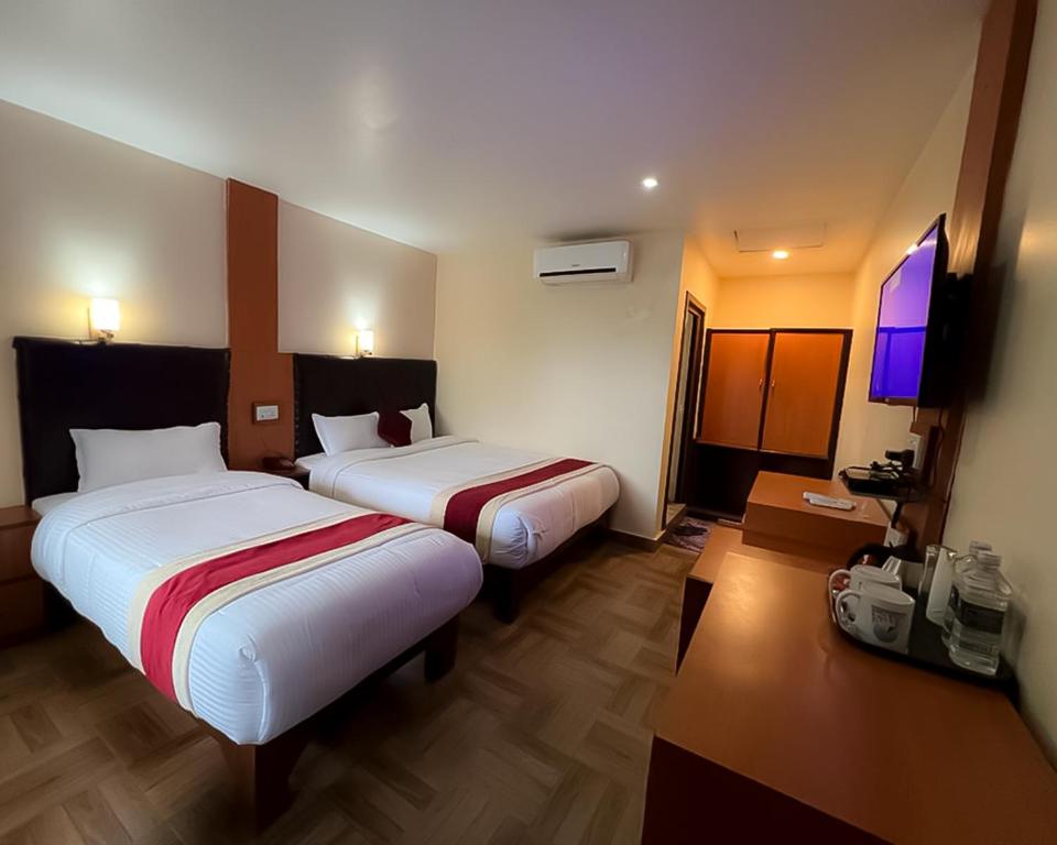索拉哈Ama Garden Sauraha的酒店客房设有两张床和一台平面电视。