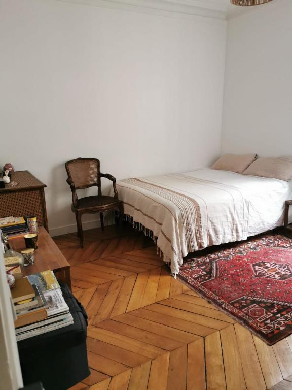 巴黎Home sweet home的卧室配有1张床、1张桌子和1把椅子