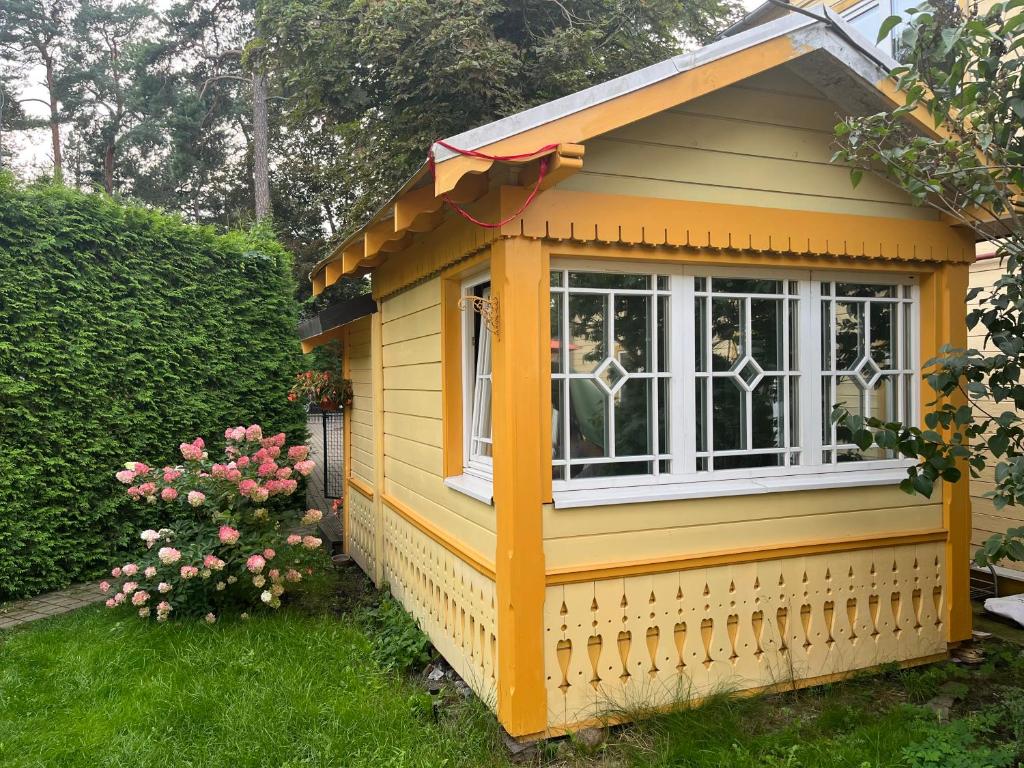 尤尔马拉Jurmala`s Center Mini House的院子中带窗户的小黄色房子