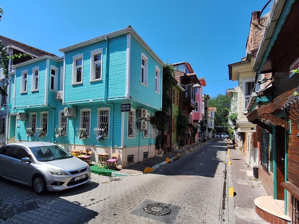 伊斯坦布尔Fidelya Boutique Hotel的街上有多彩的房子和一辆汽车
