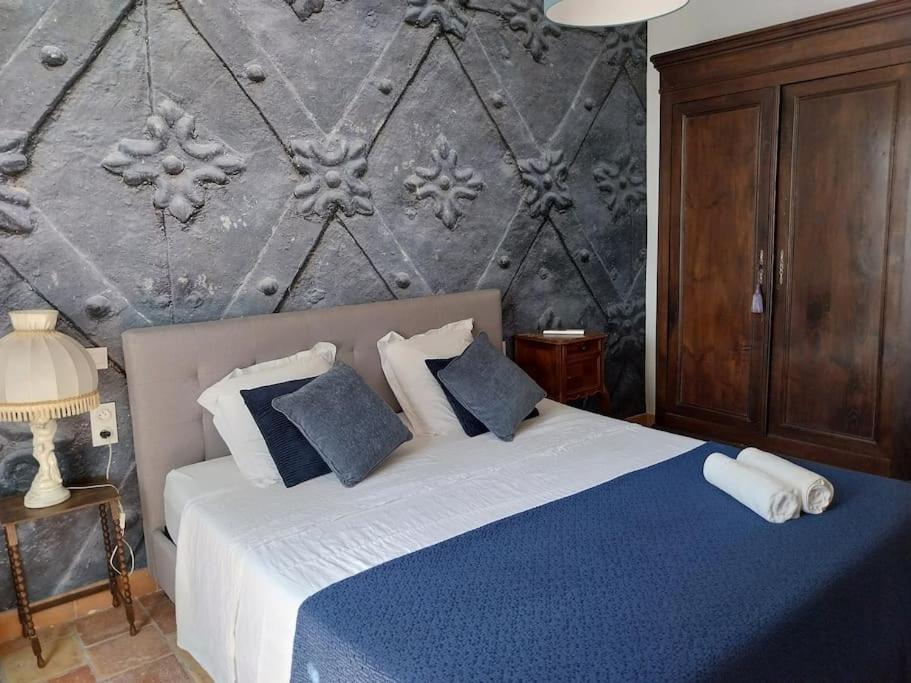 特雷布Château sur le Canal du midi proche de Carcassonne的一间卧室配有一张带蓝色和白色枕头的床