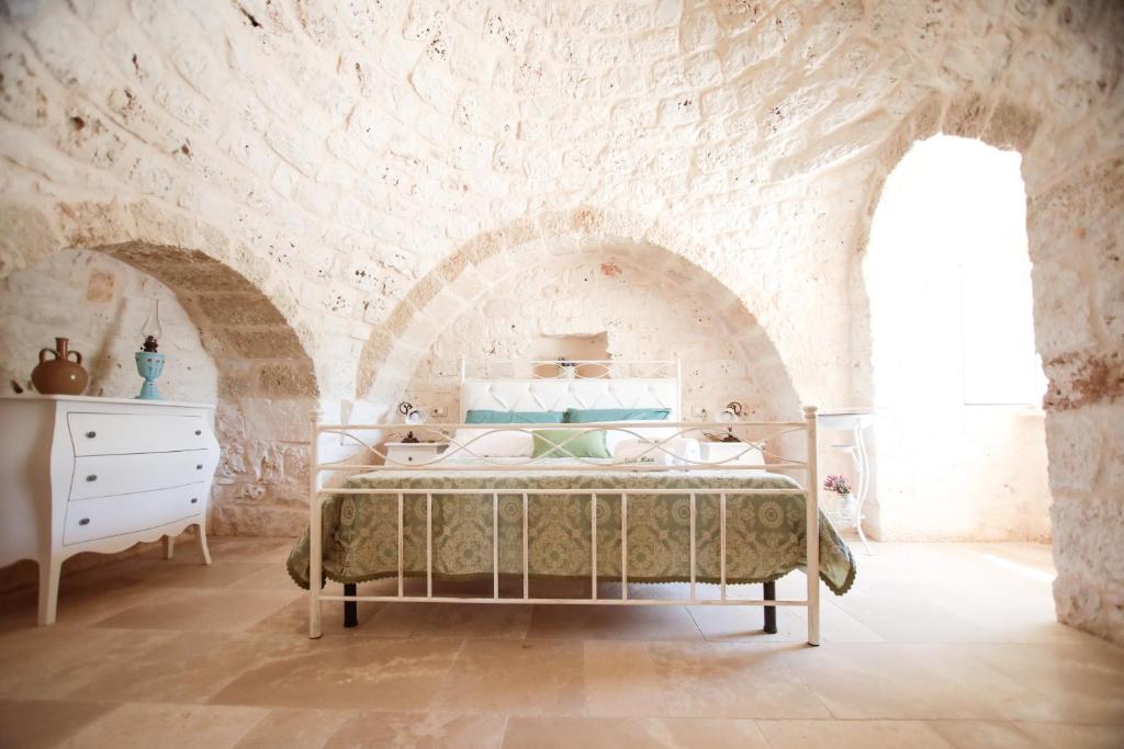 奥斯图尼Villa Mina的卧室配有一张石墙床