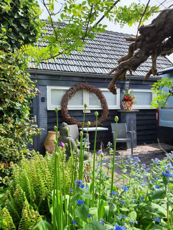 LutjewinkelTuinhuis的房屋前设有带桌椅的花园