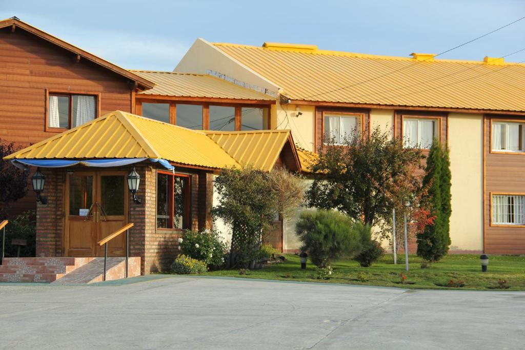 埃尔卡拉法特皮科斯戴尔苏尔酒店的黄色屋顶和车道的房子