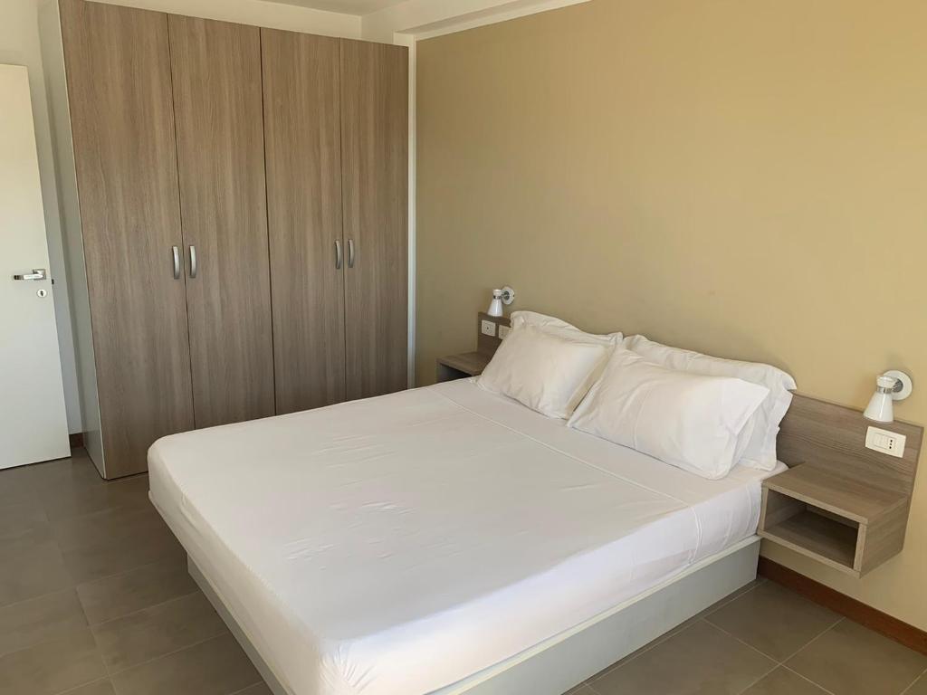 明德卢Lazareto Oceanview的卧室配有一张白色大床和木制橱柜。