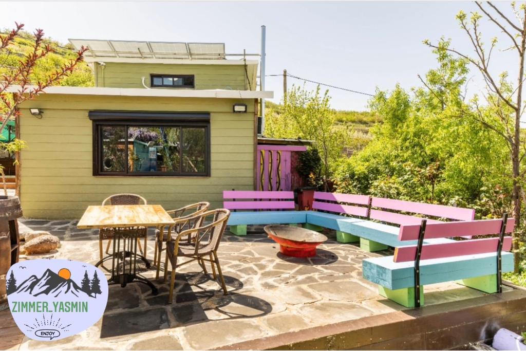 迈季代勒舍姆斯בקתה ואירוח היסמין מול הנוף的庭院设有长凳和桌椅。