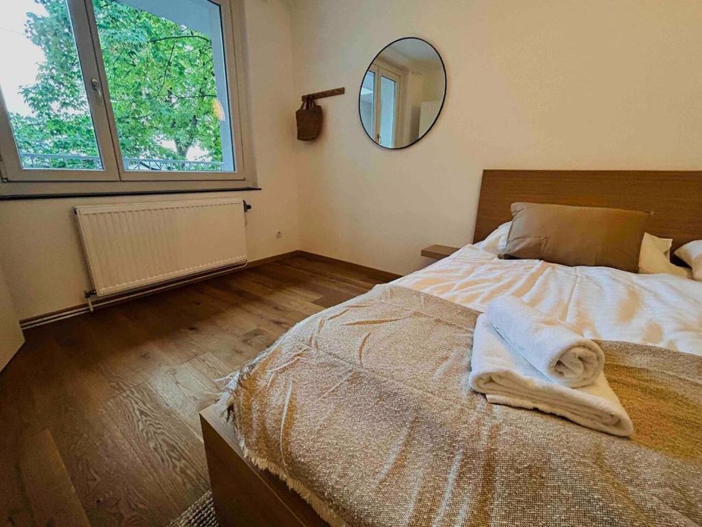 维也纳Urbaner Charme: Stilvolles Wohnen im Herzen Wiens的卧室配有一张壁挂镜子的床