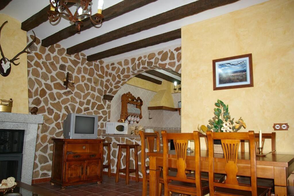 San Pablo de los MontesCasa Rural Cristina I的厨房以及带桌子和电视的用餐室。