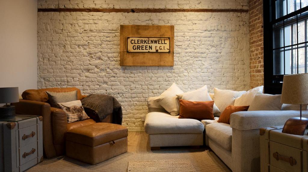 伦敦Stylish City Clerkenwell的客厅设有两张沙发和砖墙