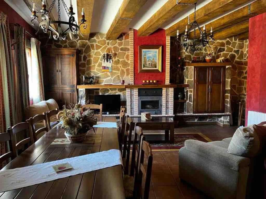 San Pablo de los MontesCasa Rural Cristina III的客厅配有桌子和石头壁炉