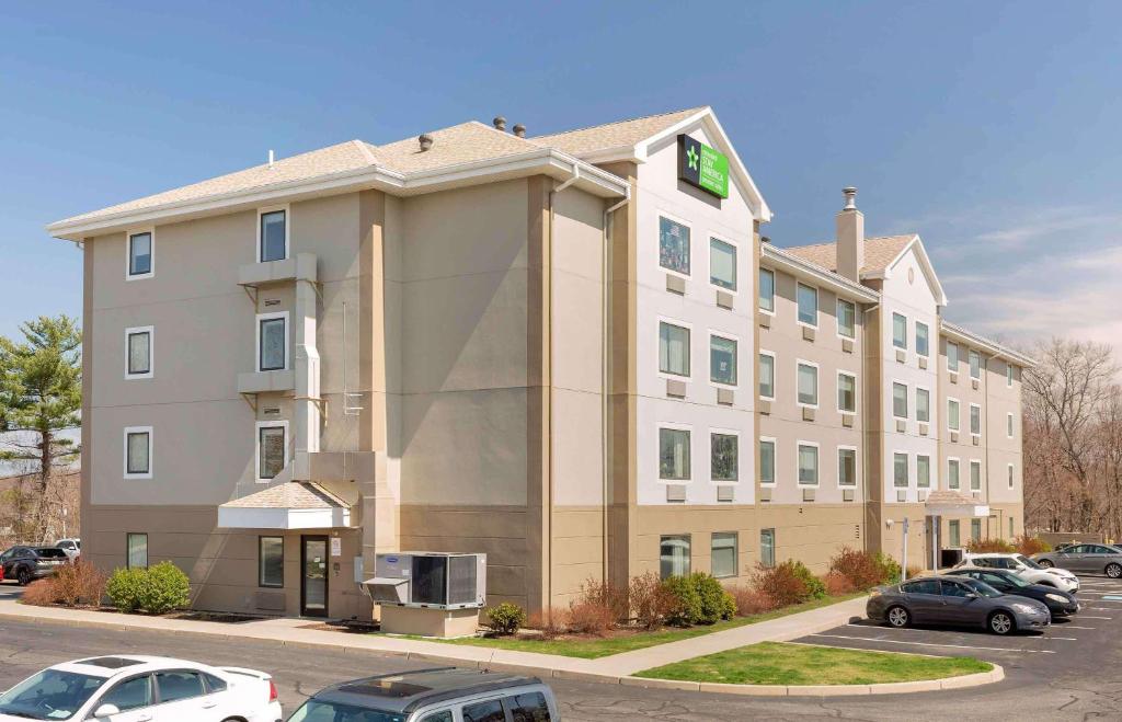 East ProvidenceExtended Stay America Premier Suites - Providence - East Providence的停车场内停放汽车的酒店大楼