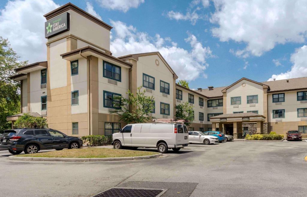奥兰多Extended Stay America Select Suites - Orlando - Maitland - 1760 Pembrook Dr的停车场内有车辆的旅馆