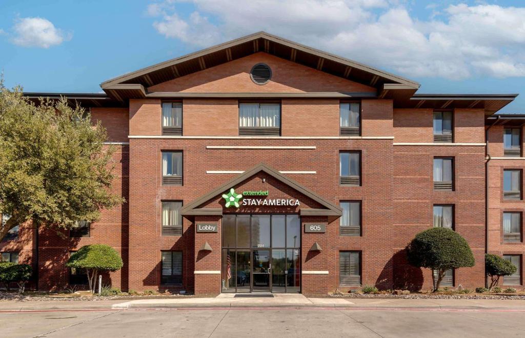 欧文Extended Stay America Select Suites - Dallas - Las Colinas - Meadow Creek Dr的一座大型红砖建筑,上面有超市标志