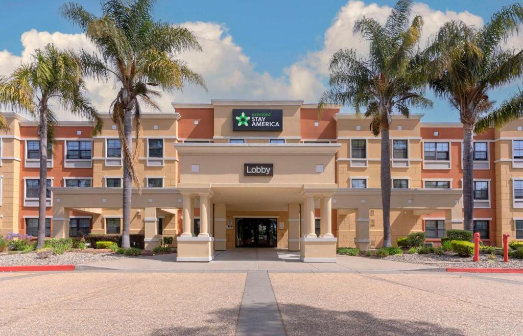 阿拉米达奥克兰 - 阿拉米达机场长住酒店的一座楼前有棕榈树的酒店