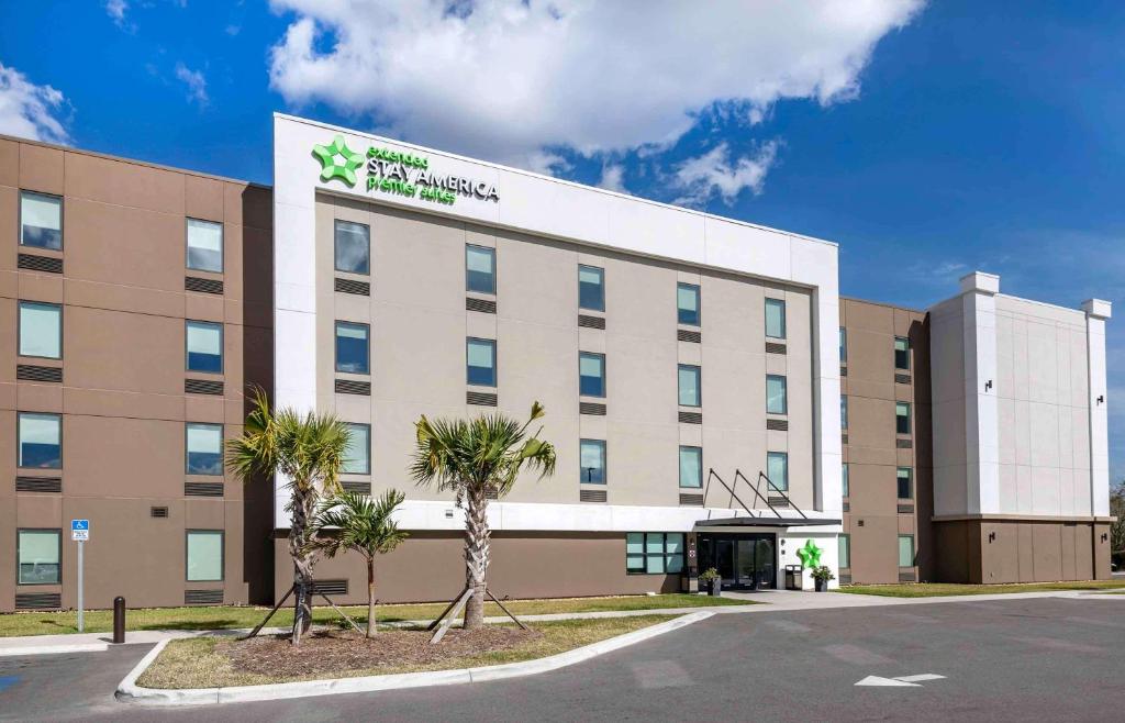 坦帕Extended Stay America Premier Suites - Tampa - Fairgrounds - Casino的一座酒店大楼,前面有棕榈树