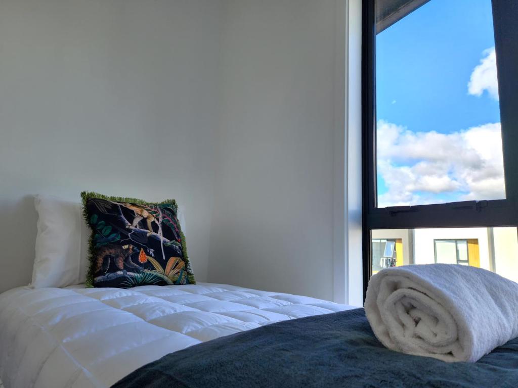 帕拉帕拉乌穆U Suites on Trieste Way的窗户间里一张带毛巾的床