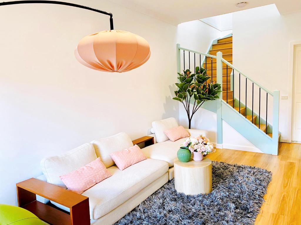 墨尔本The Daisy House - Family-friendly & top convenient location的客厅配有白色沙发和粉红色枕头。
