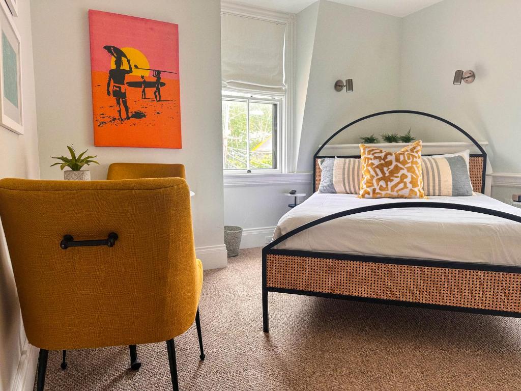 楠塔基特The Centerboard Nantucket的一间卧室配有一张床和一把椅子