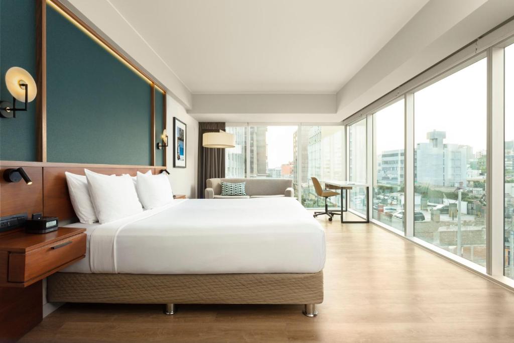 利马利马米拉弗洛雷斯万怡酒店的一间卧室设有一张大床和一个大窗户