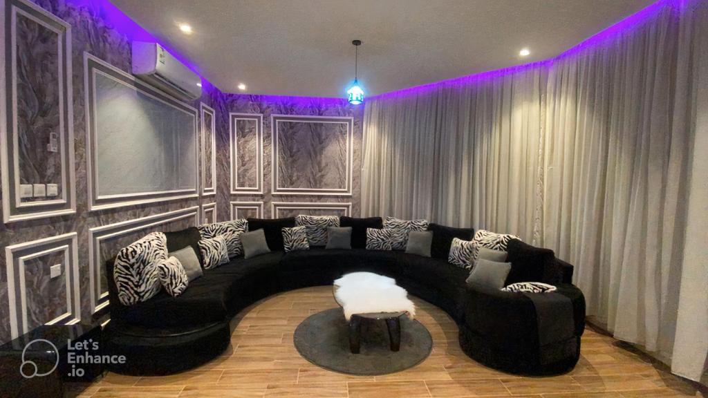 Yanbu Al Bahrشاليه العماريه的客厅配有黑色沙发和桌子
