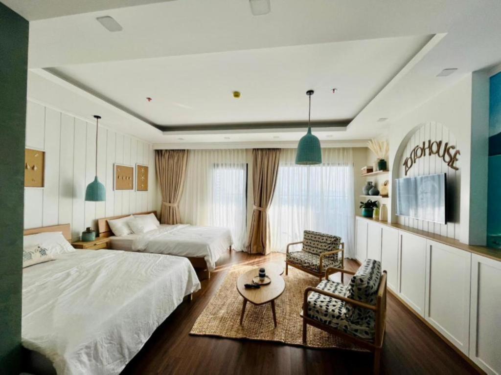 归仁FLC Sea Tower Quy Nhơn - Homostay的一间卧室配有两张床和一张桌子及椅子
