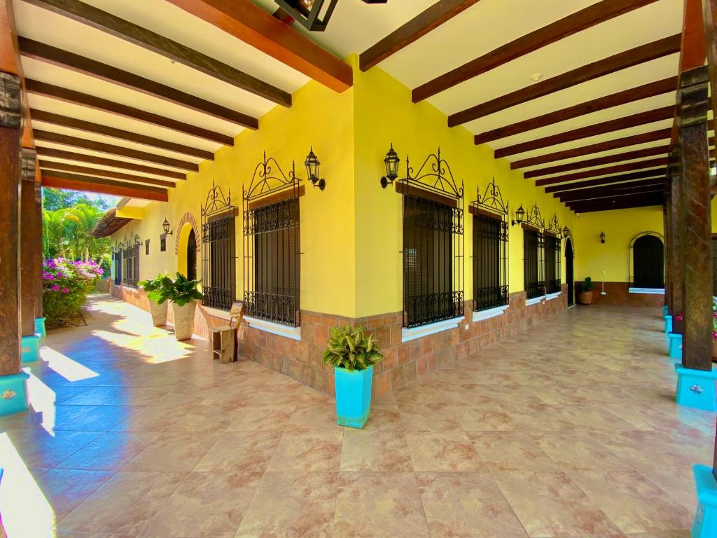 LemosCasa Colonial San Alejo的一座拥有黄色墙壁的建筑和一个种有盆栽植物的庭院