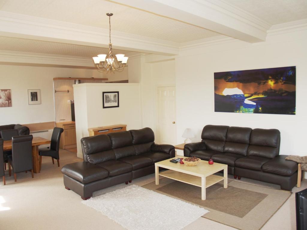 爱丁堡爱丁堡皇家大道公寓的客厅配有黑色皮革家具和桌子