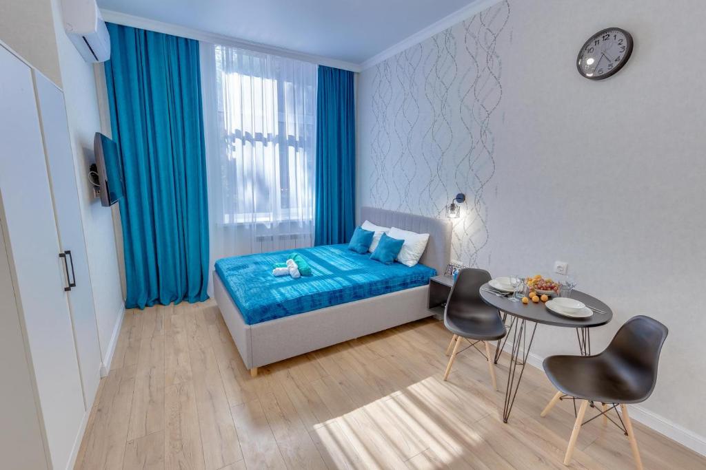 阿拉木图Asaapart Vernyi Room 3的一间卧室配有蓝色的床和桌椅