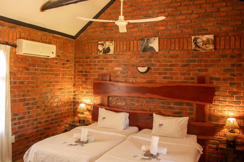 GrootfonteinFiume Lodge CC的砖墙客房的两张床
