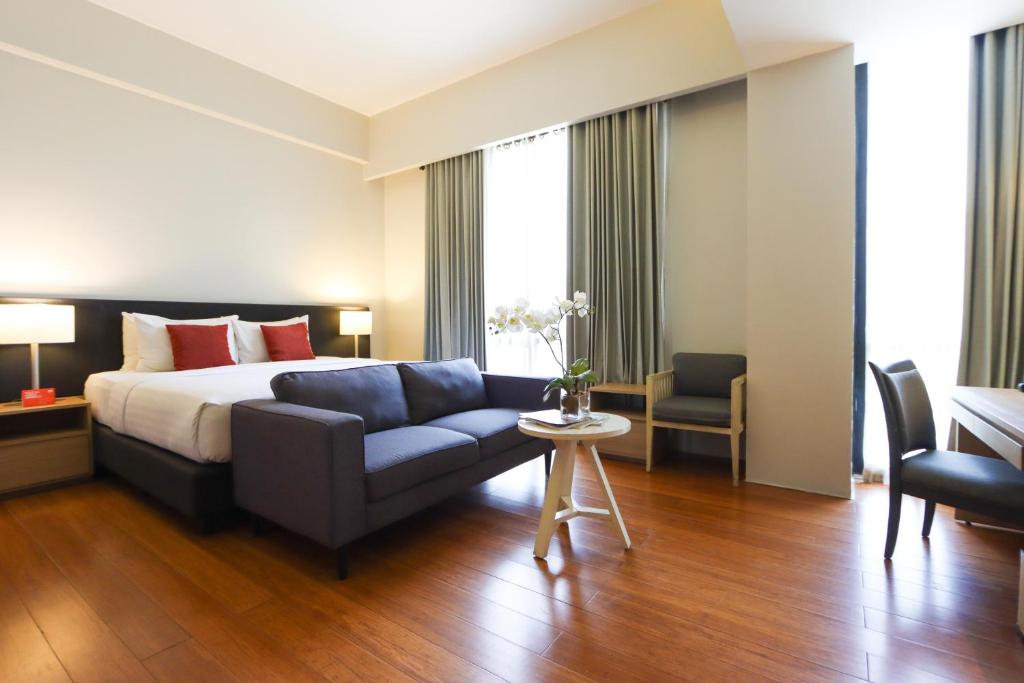 马尼拉Privato Quezon City的酒店客房,配有床和沙发