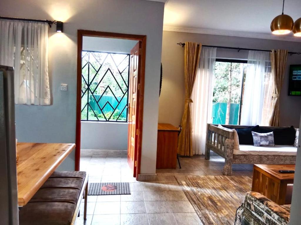 内罗毕Kingfisher Cottage的带沙发和彩色玻璃窗的客厅