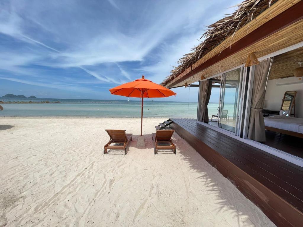 西塔努尼斯海度假村的海滩上的两把椅子和一把遮阳伞