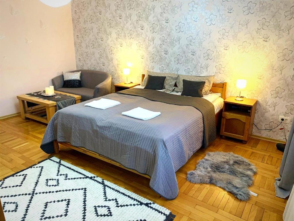GhimbavAndreea Residence的一间卧室配有一张床、一张沙发和一把椅子