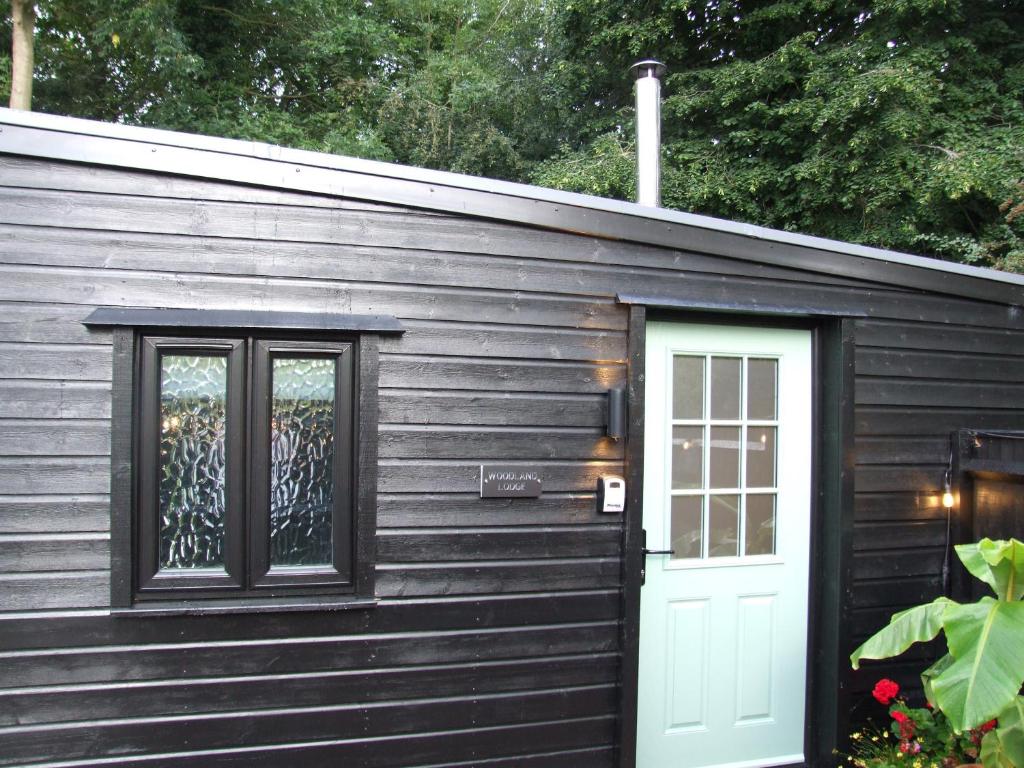 大雅茅斯Charming 1-Bed Lodge in woodland setting的小木屋设有门和窗户