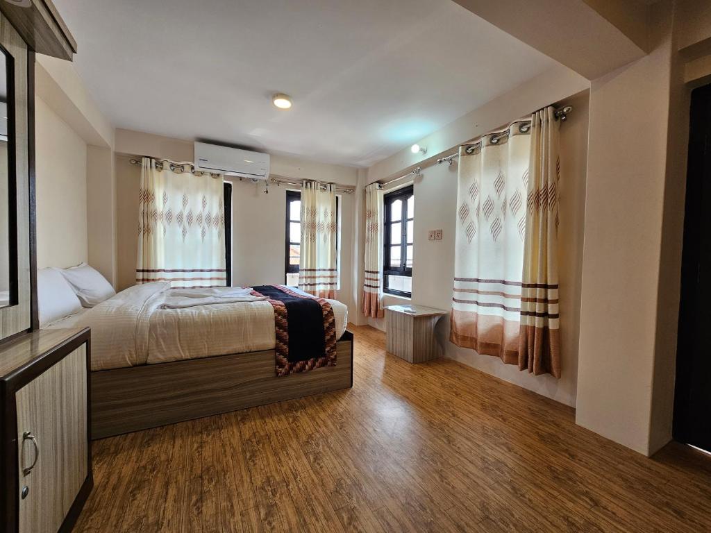 巴克塔普尔Hotel Durbar Side的一间卧室设有一张床和两个窗户。