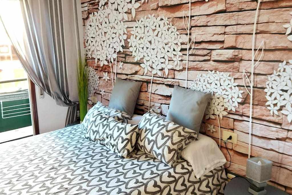 维戈Estancia acogedora en Vigo的一间卧室设有砖墙和一张带枕头的床