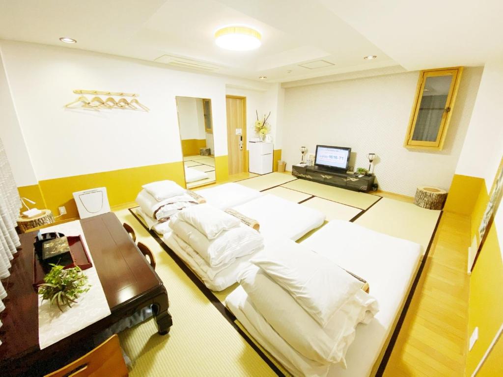 德岛Reinahill - Vacation STAY 67181v的客房设有四张床、书桌和电脑