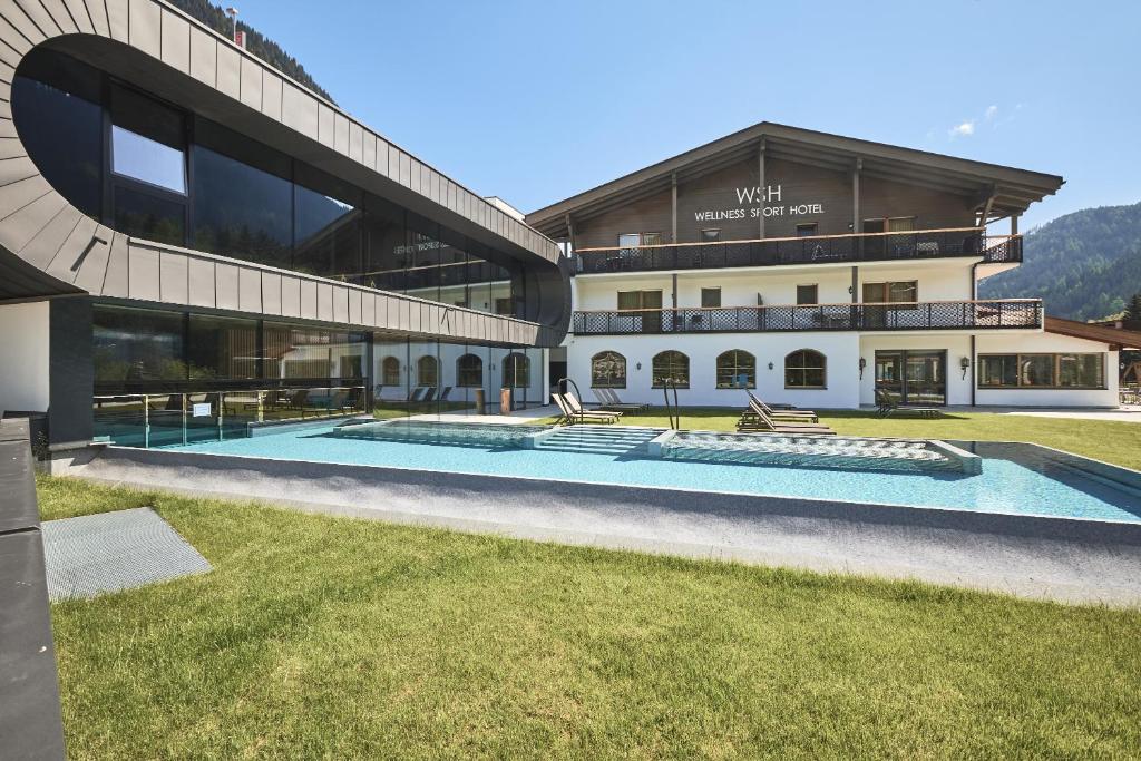 拉辛拉奇内斯康体运动酒店的享有带游泳池的建筑的外部景色