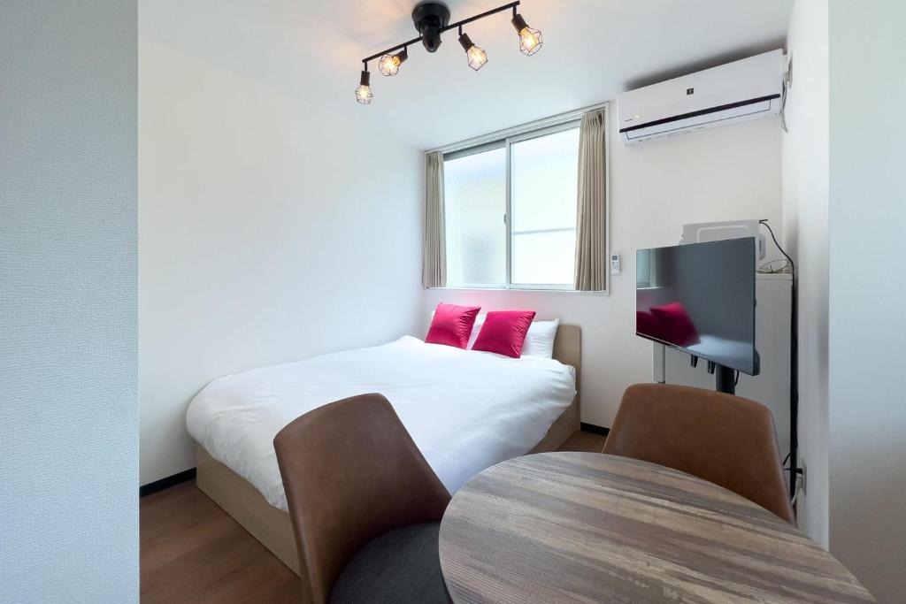 东京Elegant House的小房间设有床铺和电视